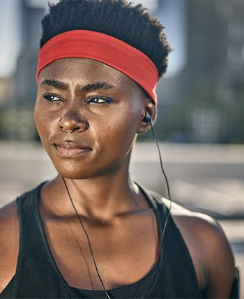 woman runner wearing headband listens to music