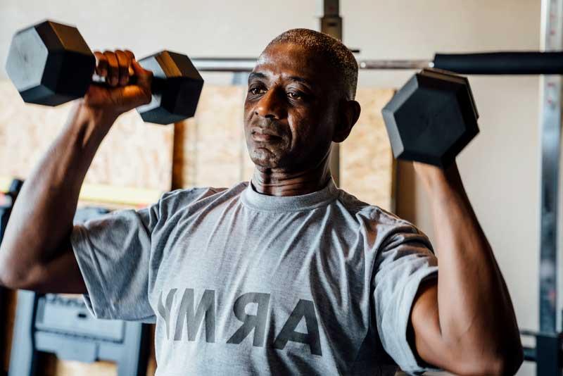 Military veteran lifting weights in garage