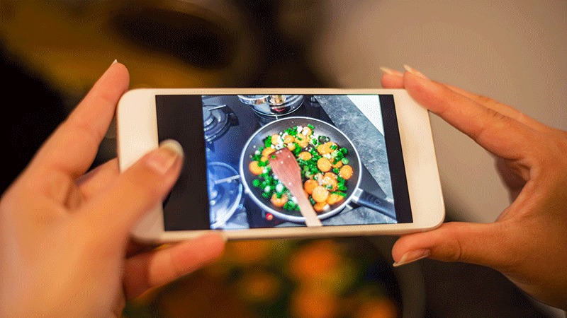 女人用智能手机拍摄食物